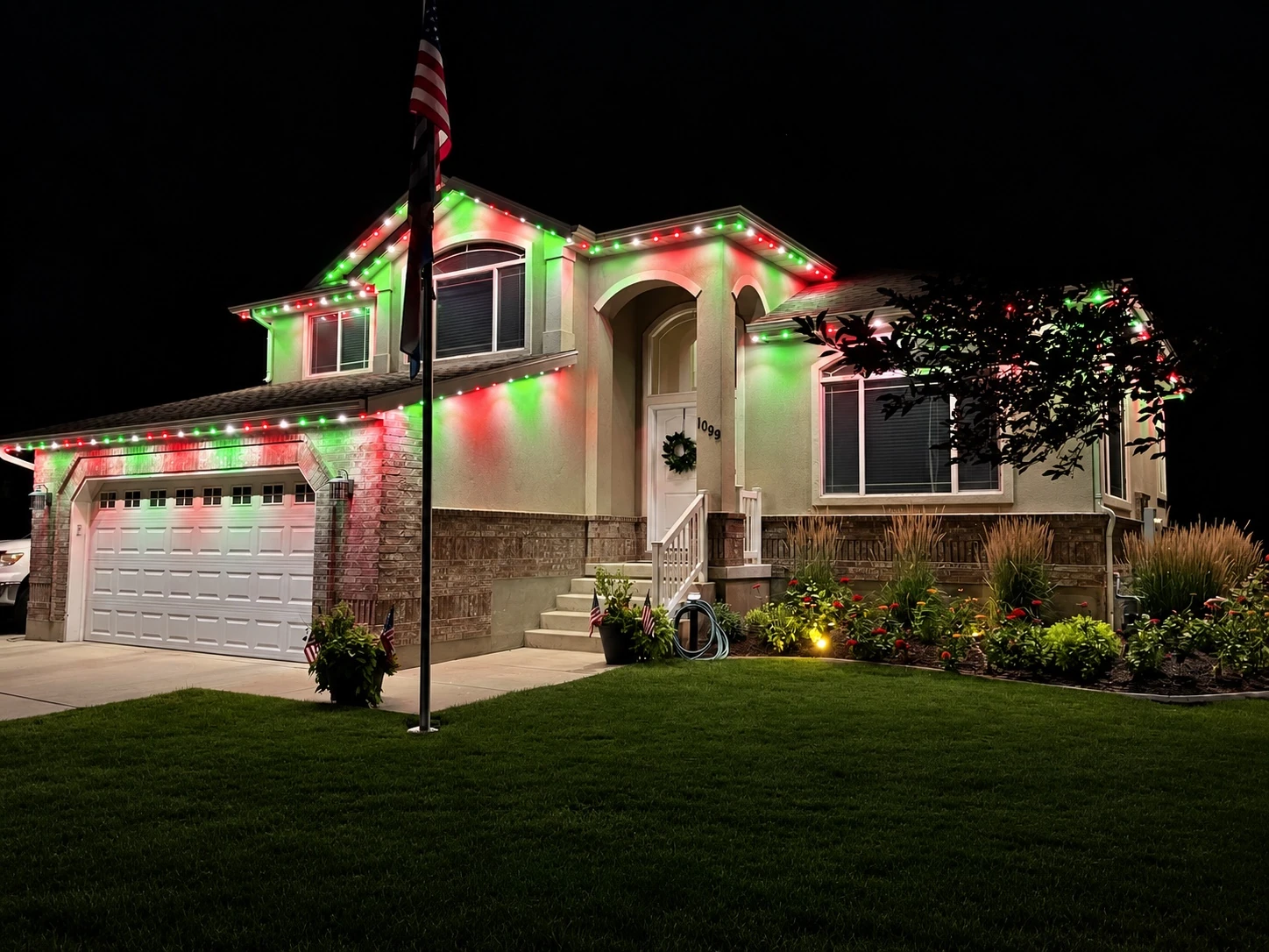 Seasonal red, green, and white lights on a split-level home