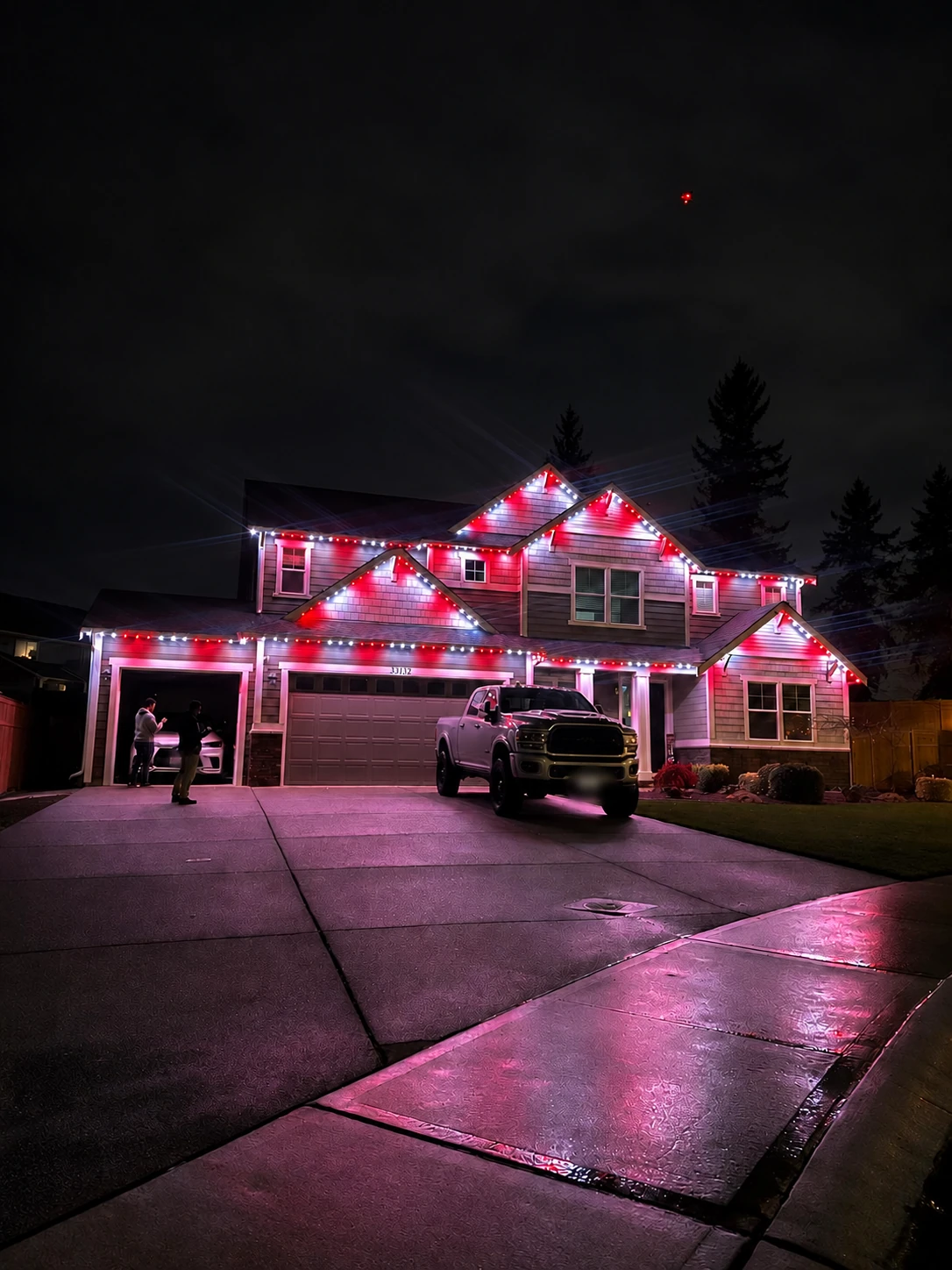 Red and white permanent lighting above a driveway