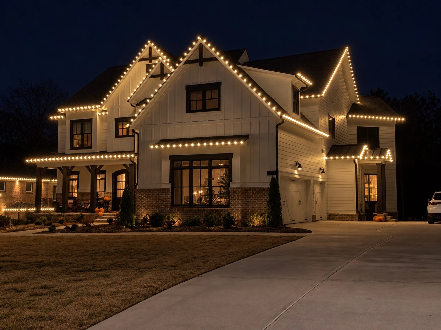 Warm white lighting on a farmhouse porch and roofline